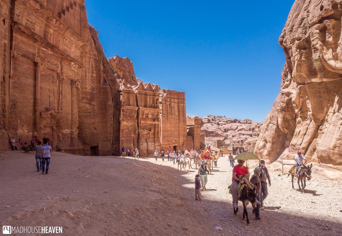 A newly discovered ancient tomb in Petra, Jordan, carved into rose-red rock cliffs, showcasing intricate Nabataean architecture and revealing recent archaeological findings.