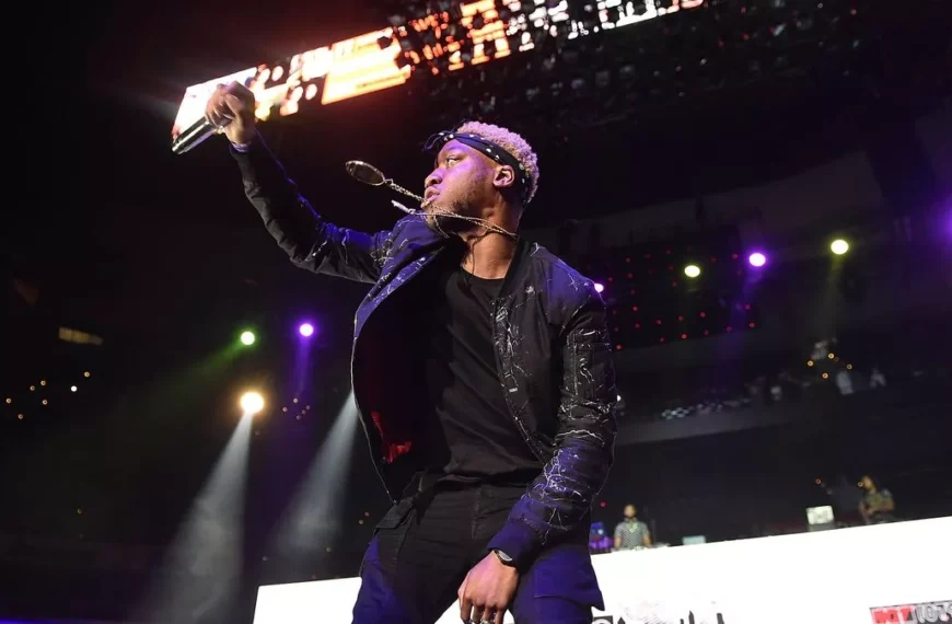 Portrait of OG Maco performing on stage, remembered for his hit "U Guessed It" and contributions to hip-hop.