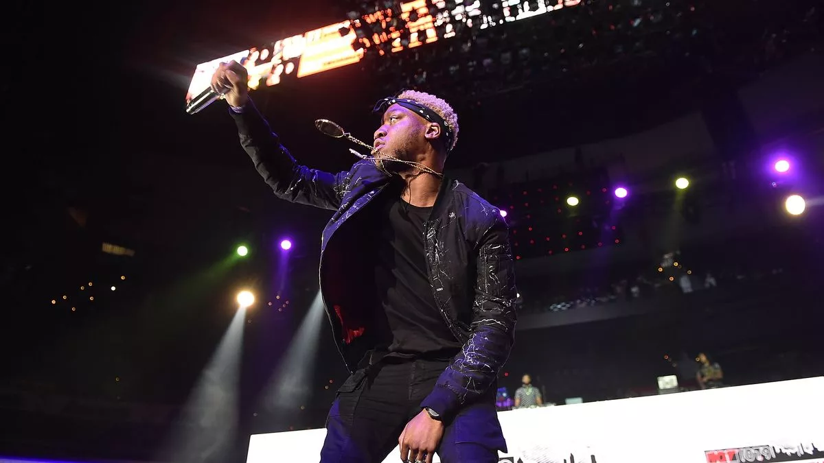 Portrait of OG Maco performing on stage, remembered for his hit "U Guessed It" and contributions to hip-hop.