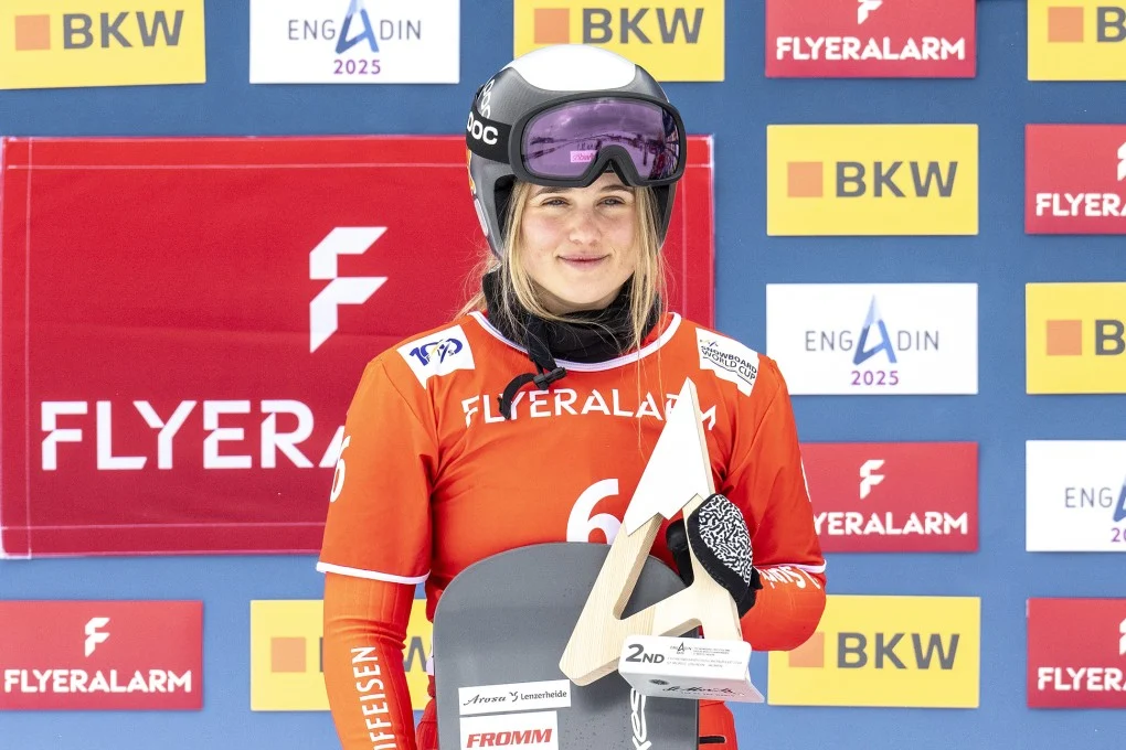 Swiss Olympic snowboarder Sophie Hediger, smiling in her snowboarding gear, remembered for her achievements and tragic passing at 26.